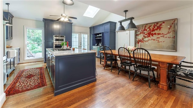 657 E Paces Ferry Rd NE, Atlanta, GA 30305 - kitchen with light wood finished floors, a skylight, double oven, vaulted ceiling, and a ceiling fan