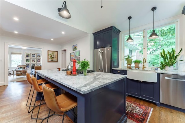 657 E Paces Ferry Rd NE, Atlanta, GA 30305 - kitchen featuring stainless steel appliances, light stone counters, wood finished floors, a kitchen breakfast bar, and crown molding