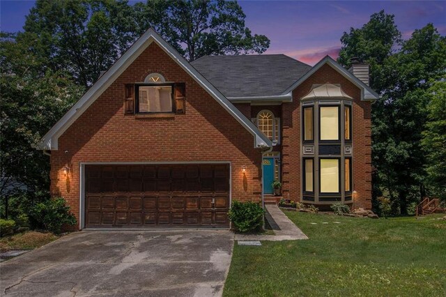 1452 Crooked Tree Cir, Stone Mountain, GA 30088 - view of front facade featuring a garage, driveway, a chimney, brick siding, and a lawn