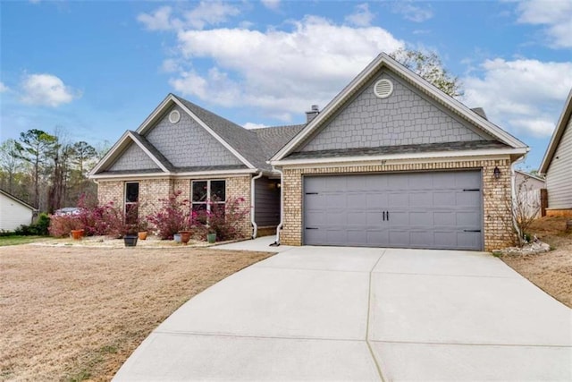 craftsman inspired home with a garage, brick siding, and driveway