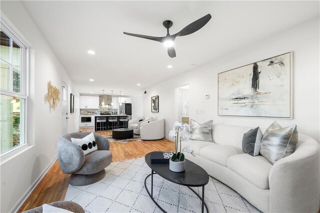 living room featuring ceiling fan and light wood-type flooring