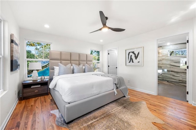 bedroom featuring ceiling fan, wood-type flooring, and multiple windows