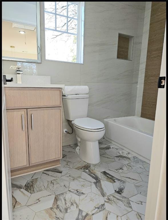 full bathroom featuring shower / washtub combination, vanity, tile walls, and toilet