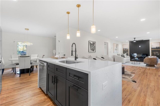 kitchen featuring ceiling fan, sink, an island with sink, and pendant lighting