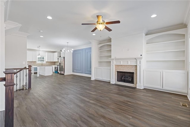 unfurnished living room featuring dark wood-style floors, a fireplace, recessed lighting, visible vents, and ornamental molding