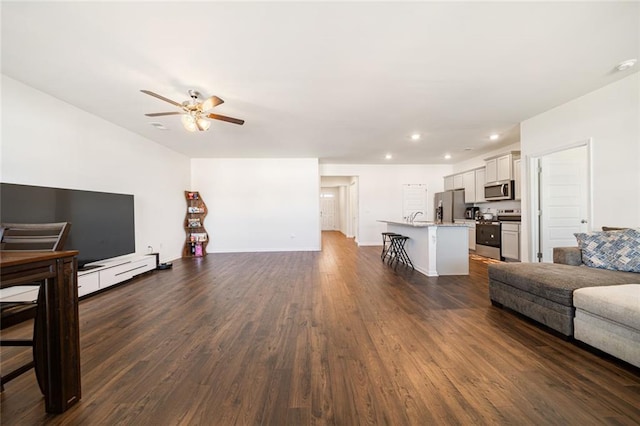 living area featuring recessed lighting, dark wood finished floors, baseboards, and ceiling fan