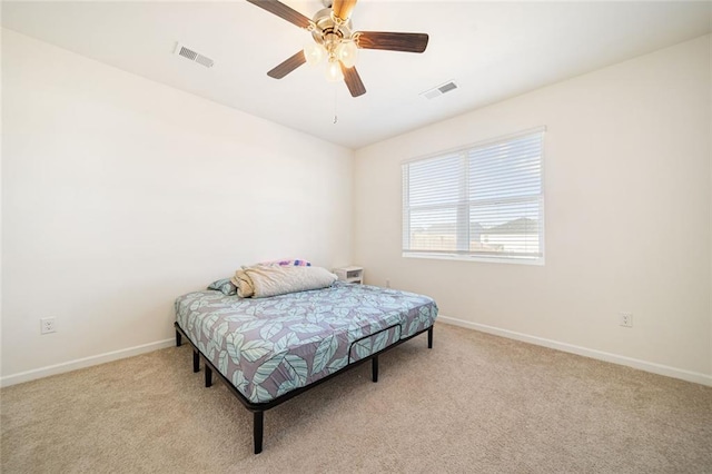 bedroom with baseboards, visible vents, and light colored carpet