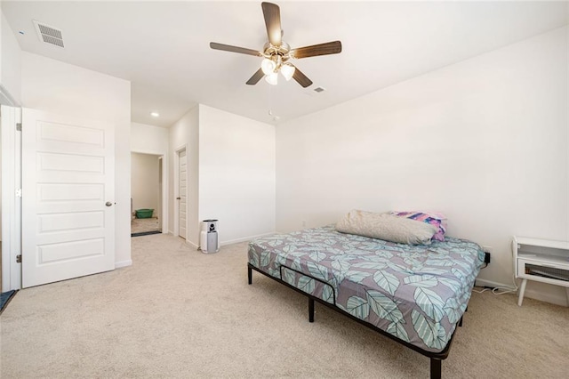 bedroom with a ceiling fan, light colored carpet, visible vents, and baseboards