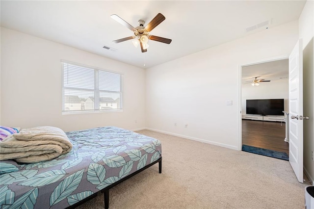 bedroom featuring carpet floors, a ceiling fan, visible vents, and baseboards