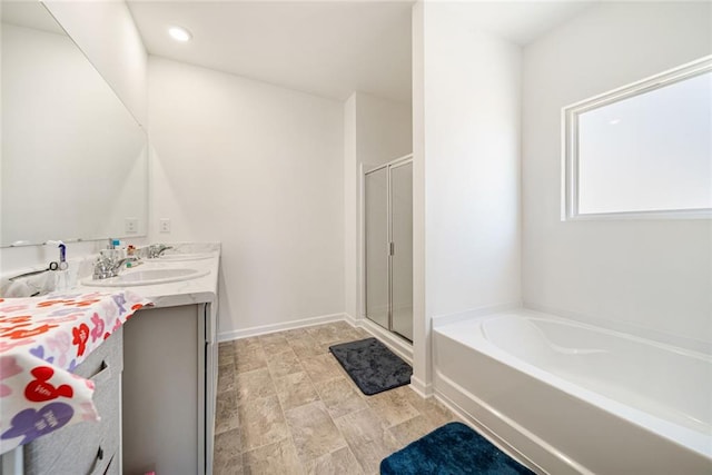 bathroom featuring a bath, a shower stall, vanity, and baseboards