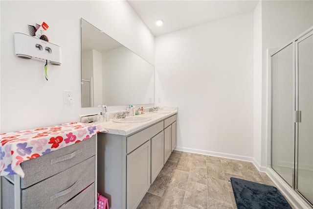 full bathroom with a shower stall, baseboards, and vanity