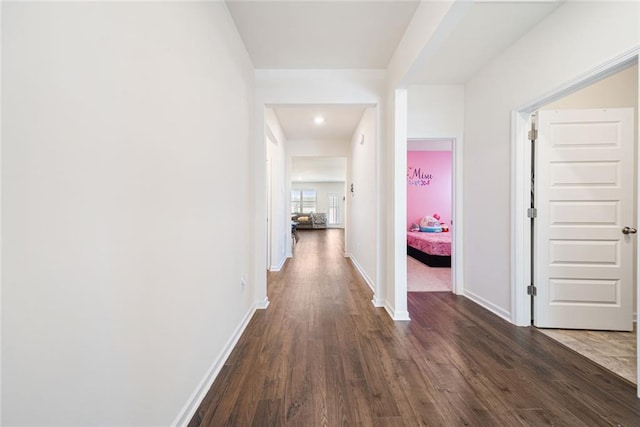 corridor featuring dark wood-style floors and baseboards