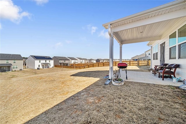 view of yard with a patio area, fence, and a residential view