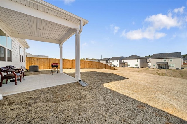 view of yard featuring a residential view, a patio area, fence, and central air condition unit