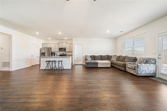 living area featuring recessed lighting, visible vents, dark wood finished floors, and baseboards