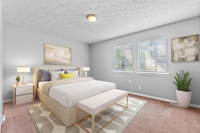 bedroom featuring light carpet and a textured ceiling