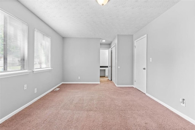 carpeted spare room featuring a textured ceiling