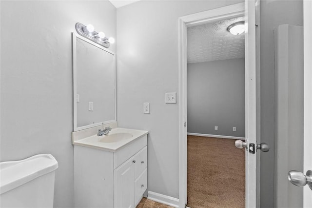 bathroom with vanity, a textured ceiling, and toilet