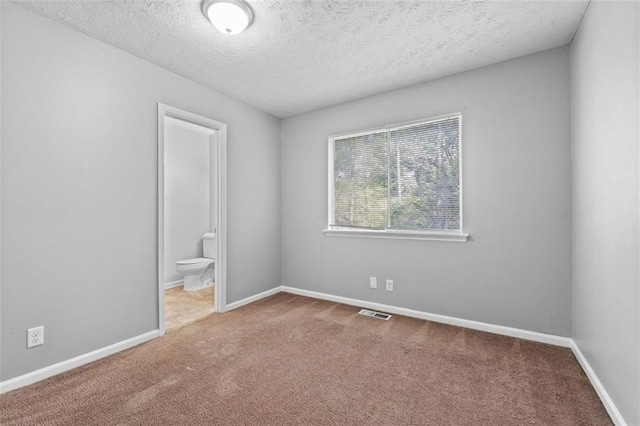 carpeted empty room featuring a textured ceiling