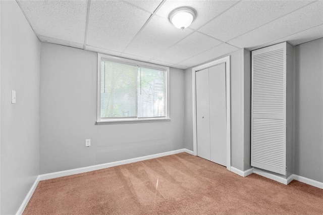 unfurnished bedroom with a paneled ceiling and light colored carpet