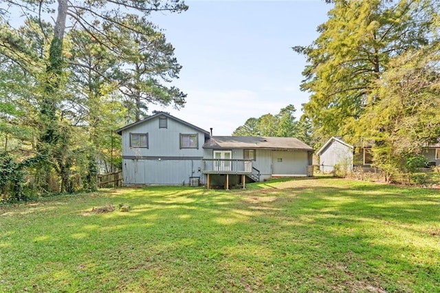 rear view of house featuring a deck and a yard