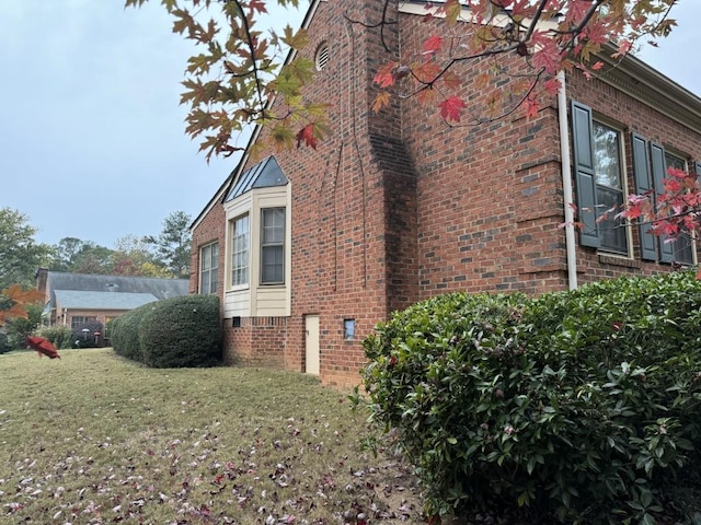 view of side of home with a yard