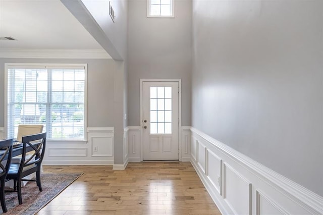 4765 Silver Leaf Dr, Cumming, GA 30040 - entrance foyer featuring a wainscoted wall, ornamental molding, light wood-type flooring, healthy amount of natural light, and a decorative wall