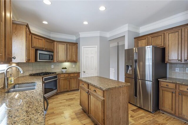4765 Silver Leaf Dr, Cumming, GA 30040 - kitchen with appliances with stainless steel finishes, brown cabinets, stone counters, light wood finished floors, and crown molding