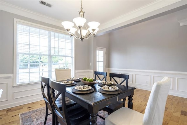 4765 Silver Leaf Dr, Cumming, GA 30040 - dining space featuring a wainscoted wall, ornamental molding, a chandelier, and light wood-style flooring