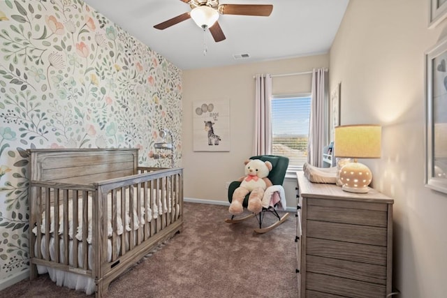 bedroom with a nursery area, ceiling fan, and carpet floors