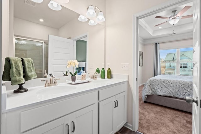 bathroom with ceiling fan, an enclosed shower, vanity, a tray ceiling, and ornamental molding