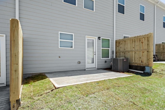 rear view of property with cooling unit, a yard, and a patio area