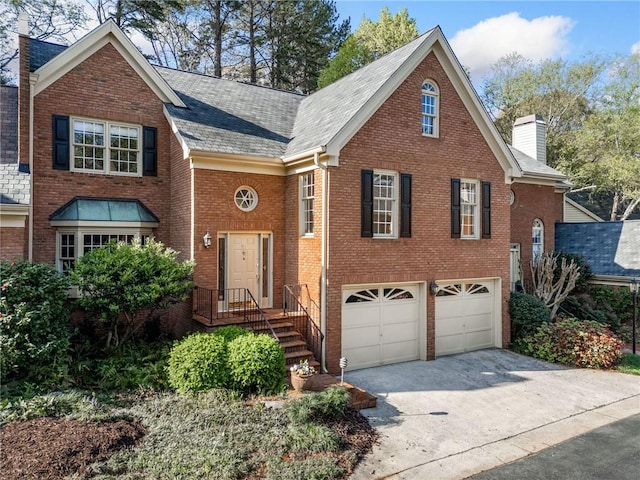 view of front facade with a chimney, brick siding, concrete driveway, and a garage