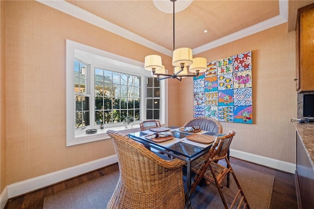 dining space with dark wood-type flooring, a chandelier, baseboards, and ornamental molding
