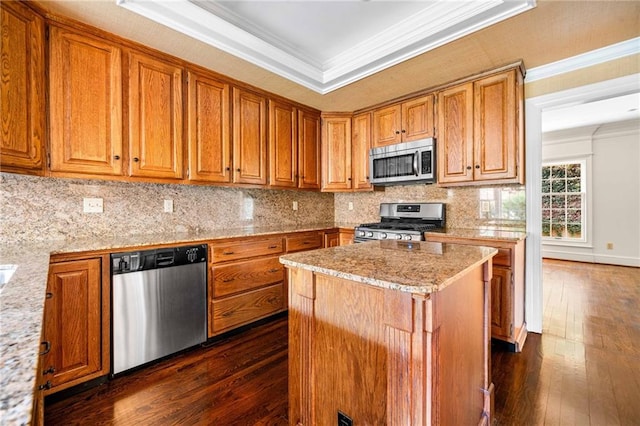kitchen featuring crown molding, brown cabinetry, stainless steel appliances, backsplash, and dark wood-style floors