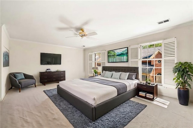 bedroom featuring ceiling fan, carpet floors, crown molding, and visible vents