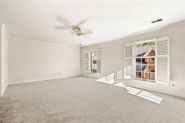 empty room featuring ceiling fan, carpet floors, ornamental molding, and visible vents