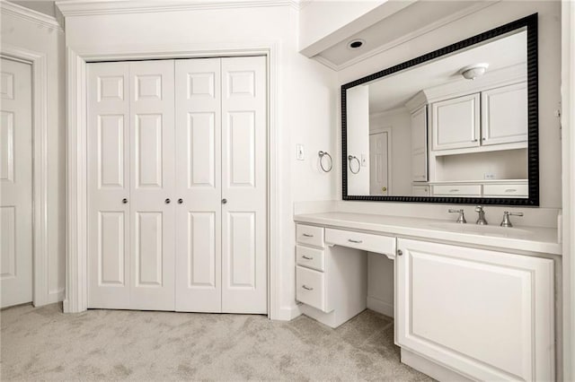 bathroom with carpet, a closet, vanity, and ornamental molding