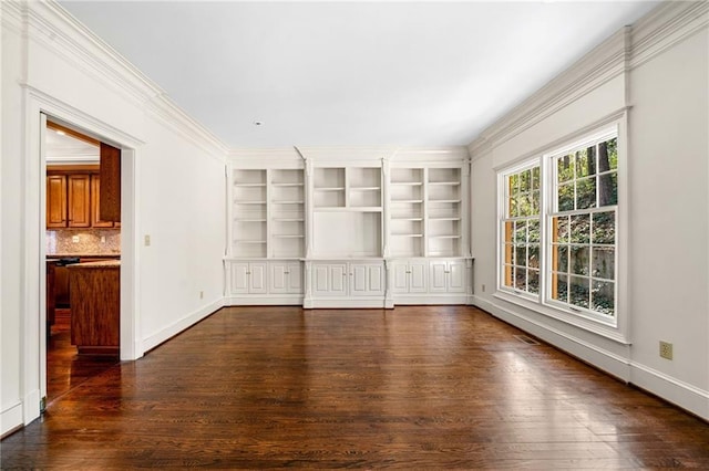 unfurnished room featuring dark wood-type flooring, built in features, baseboards, and ornamental molding