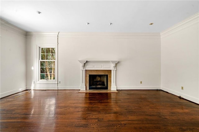 unfurnished living room with a fireplace with flush hearth, baseboards, ornamental molding, and wood finished floors