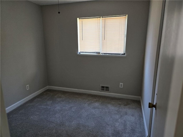 unfurnished room featuring dark colored carpet