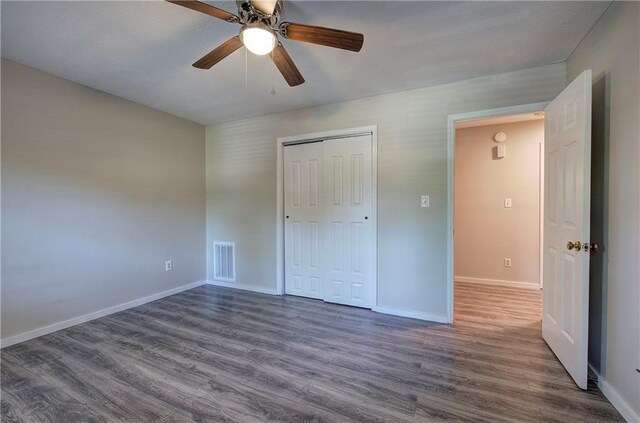 331 Leafmore Rd SW, Rome, GA 30165 - unfurnished bedroom featuring dark wood-style floors, baseboards, a closet, and a ceiling fan