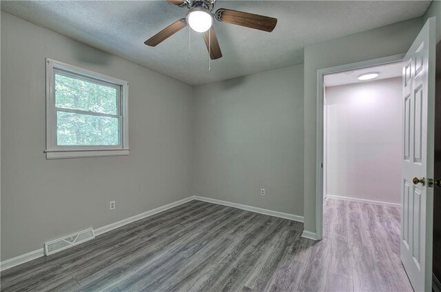 331 Leafmore Rd SW, Rome, GA 30165 - spare room with wood finished floors, baseboards, a textured ceiling, and ceiling fan