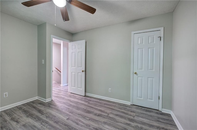 331 Leafmore Rd SW, Rome, GA 30165 - unfurnished bedroom featuring wood finished floors, a textured ceiling, baseboards, and ceiling fan