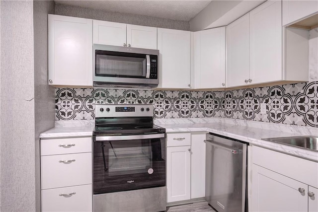 331 Leafmore Rd SW, Rome, GA 30165 - kitchen with appliances with stainless steel finishes, white cabinetry, and backsplash
