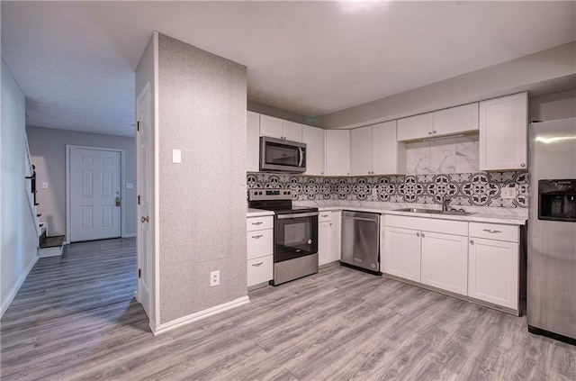 331 Leafmore Rd SW, Rome, GA 30165 - kitchen with appliances with stainless steel finishes, a sink, light countertops, light wood-style flooring, and white cabinetry