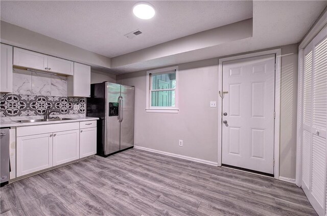 331 Leafmore Rd SW, Rome, GA 30165 - kitchen featuring stainless steel fridge with ice dispenser, a sink, white cabinets, and light countertops