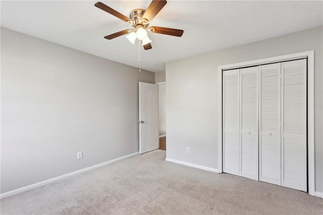 unfurnished bedroom with light colored carpet, ceiling fan, and a closet