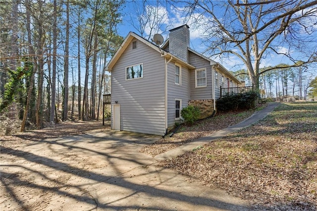 view of home's exterior featuring a garage and a deck