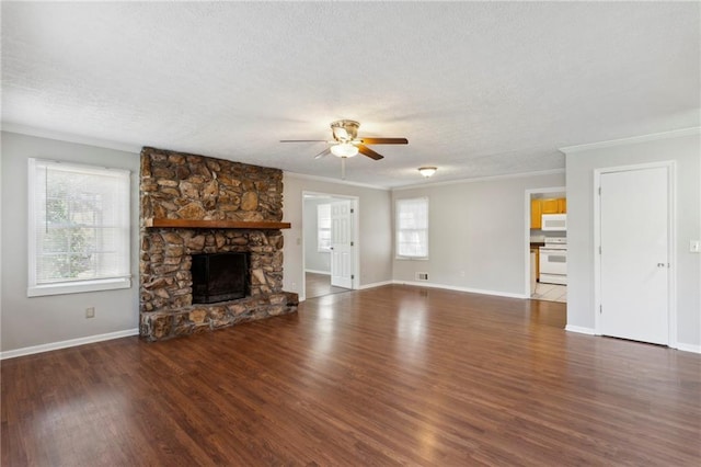 unfurnished living room with crown molding, ceiling fan, dark hardwood / wood-style floors, a fireplace, and a textured ceiling